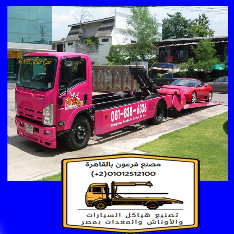 شاحنة سحب سيارات باللون الوردي تحمل سيارة حمراء على منصة النقل مع تفاصيل واضحة للعلامة التجارية.